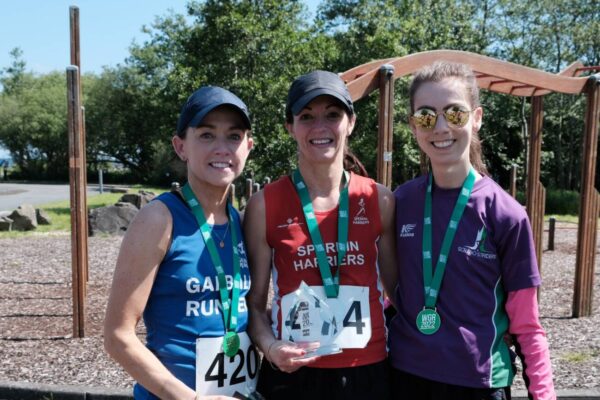 Joanne Taggart (centre) with her trophy for taking first lady in the half marathon at the Washingbay Green Run